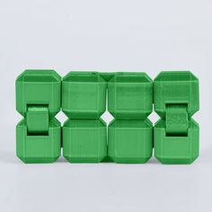 six green plastic blocks stacked on top of each other in the shape of an x