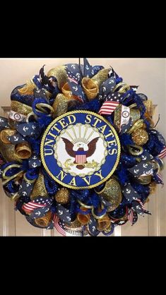 the united states navy wreath is hanging on the door with american flags and gold bells