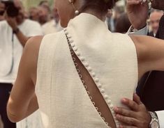 the back of a woman's dress with pearls on it