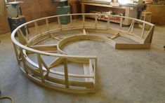 there is a circular wooden structure in the middle of a room with tools on it