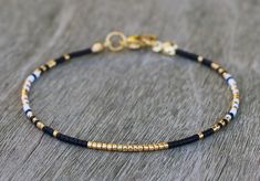 Dainty gold bracelet for women, made with very tiny Miyuki glass beads in gold, black and white. This thin bead bracelet has a stainless steel gold lobster clasp. This delicate bracelet stands perfect on its own (minimalist style), or combine with other bracelets to create your personal stack! MATERIALS: -11/0 Miyuki delicas (1.6mm x 1.3mm) -stainless steel gold colored closure DIMENSIONS: Choose your size in the variations (note: you choose the size of the bracelet, not the wrist circumference! Miyuki Delica Bracelet, Black And Gold Bracelet, Miyuki Bracelet Tutorial, Bracelet Stands, Festival Bracelets, Turquoise Anklet, Bracelet Love, Bracelet Miyuki, Beaded Ankle Bracelets