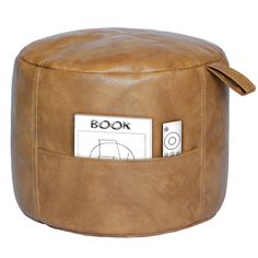 a brown leather poufce with a book on the front and an electronic device attached to it