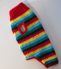 a red and blue striped knitted cell phone case sitting on top of a white surface