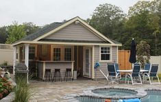 a backyard with a hot tub, patio furniture and an outdoor kitchen area in the background