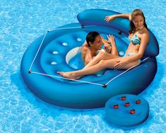 a man and woman sitting on an inflatable pool float