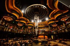 the inside of a restaurant with chandeliers and lights on it's ceiling