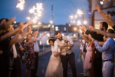 a bride and groom are surrounded by sparklers