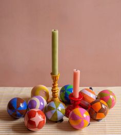 an assortment of colorfully painted eggs and a candle