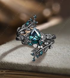 a ring with blue and white stones on it sitting on top of a table next to a book