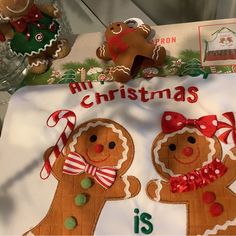 two gingerbreads are on a christmas sign with candy canes and candies