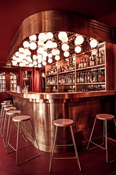 a bar with stools and lights hanging from the ceiling