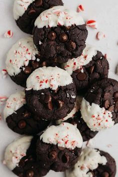 chocolate cookies with white frosting and peppermint on top are arranged in a pile