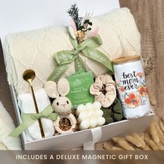 a gift box filled with baby items including a blanket, rattler and coffee mug