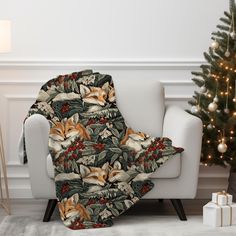 a couch with a blanket on it next to a christmas tree