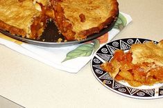 a pie on a plate next to a bowl of food