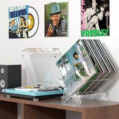 an old record player sitting on top of a wooden table next to pictures and records