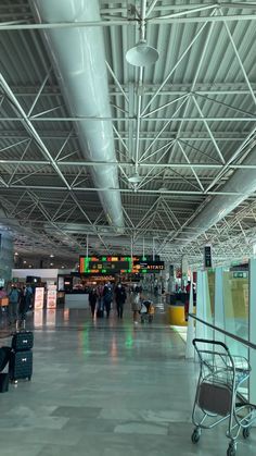 people are walking through an airport terminal with luggage on the trolleys in front of them