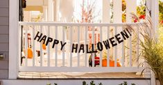 a happy halloween banner hanging on the front porch