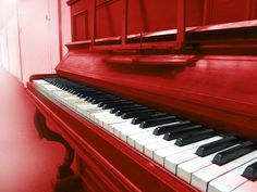 a red piano with black and white keys