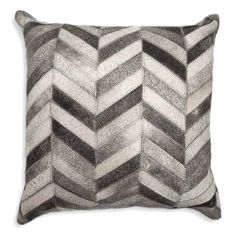 a gray and white chevroned pillow on a white background