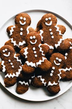 a white plate topped with ginger cookies covered in icing and sprinkles