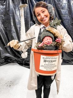 a woman holding a bucket with a baby in it