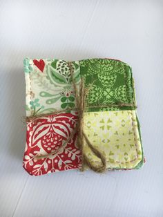 three small pieces of fabric with different patterns on them, tied together and sitting next to each other