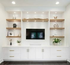 an entertainment center with white cabinets and shelves