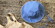 a blue hat sitting on top of a rug next to a pair of scissors and a bag