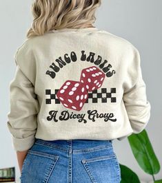 the back of a woman wearing a sweater with dice on it and words that says,'bunco babes a nice group '