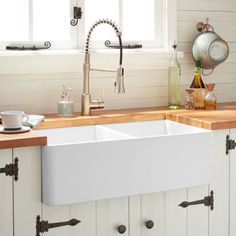 a large white sink in a kitchen next to a counter top with dishes and utensils on it