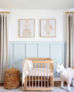 a baby's room with a crib, sheep and pictures on the wall