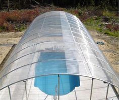 an overhead view of a swimming pool in the middle of a field with trees and bushes behind it