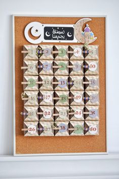 a cork board with numbers and magnets on it in arabic writing, hanging from the wall