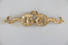 an ornate gold door handle on a white wall