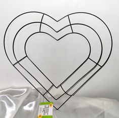 three heart shaped wire sculptures sitting on top of a white sheet