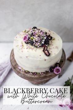 a cake with white frosting and purple flowers