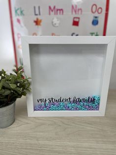 a white frame with the words my student favorite on it next to a potted plant