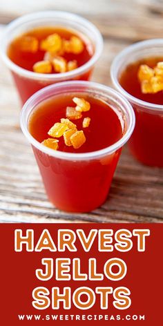 three cups filled with jello shots sitting on top of a wooden table next to the words harvest jello shots