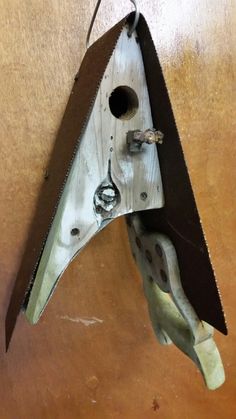 a birdhouse made out of wood and metal with a hole in the bottom half