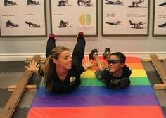 a woman and child sitting on the ground with their hands up in front of them