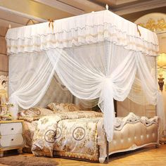 a white canopy bed sitting inside of a bedroom