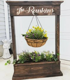 a hanging basket filled with flowers on top of a wooden stand