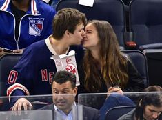 two people kissing in the stands at a hockey game