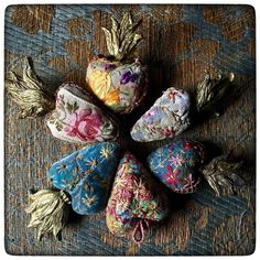 five small rocks with flowers on them are arranged in the shape of a flower arrangement