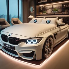 a white bmw car is parked in front of a bed with lights on the headboard