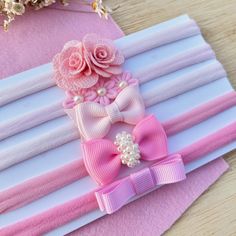 pink and white hair clips with flowers on them sitting next to folded paper napkins