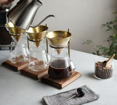 a person pours coffee into three glasses