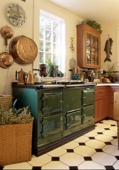 an old fashioned kitchen with pots and pans hanging on the wall above the stove