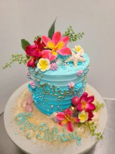 there is a blue cake with flowers on it